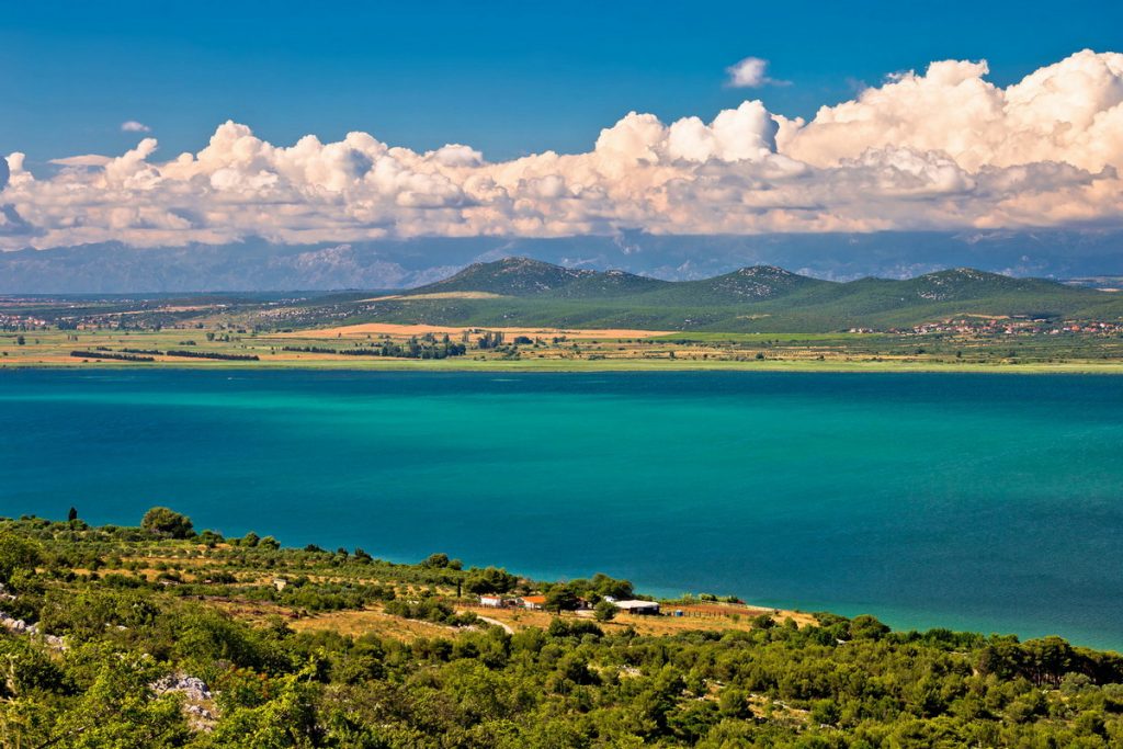 A view on Vrana lake near Zadar, Croatia with blue and green water and islands in the distance.