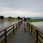 a man cycling across a wooden bridge